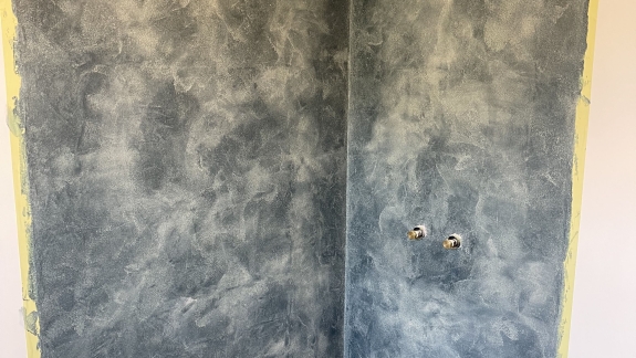Microcement væg med blåt design i microcement badeværelse
